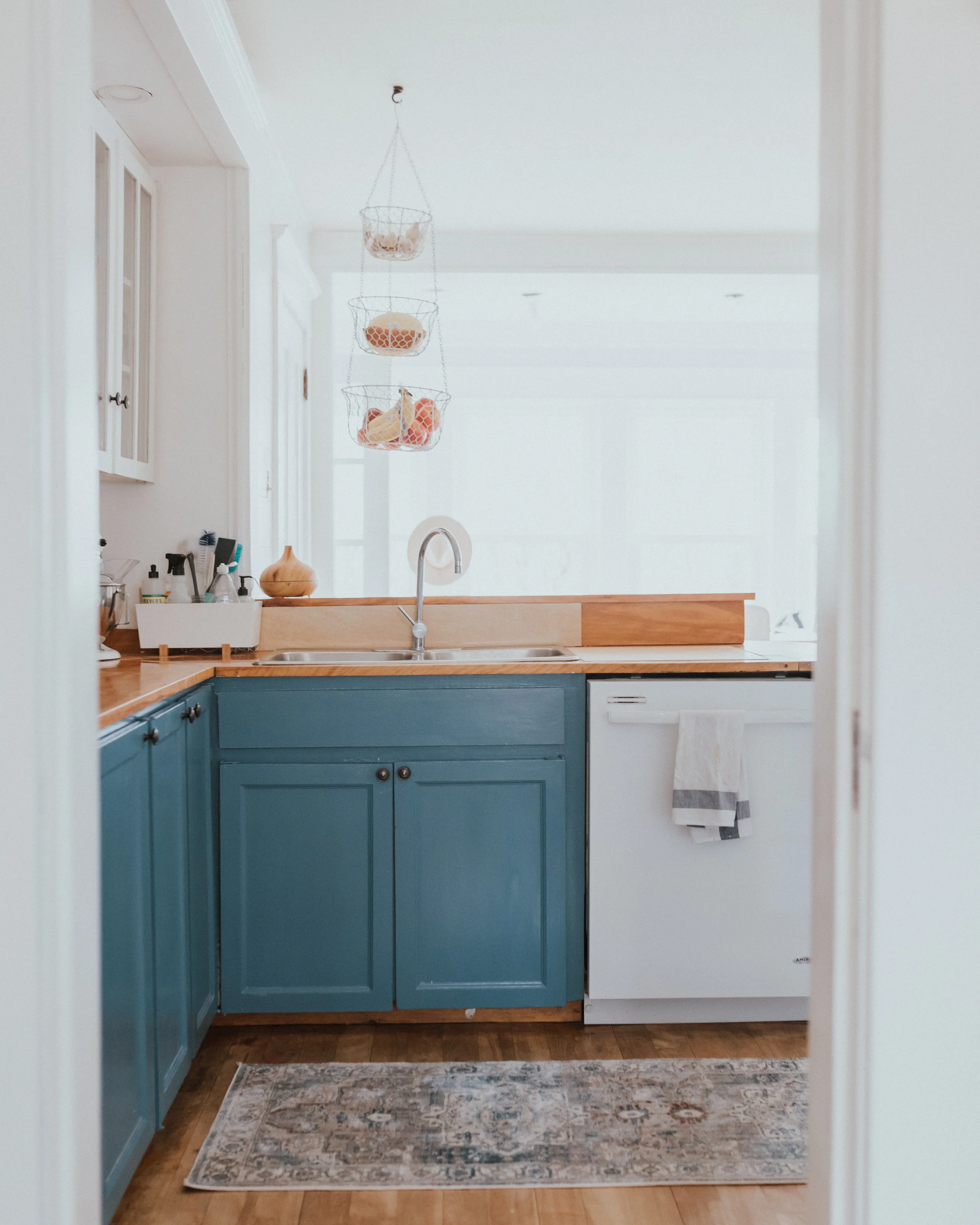 The Wild Decoelis | How We Transformed Our Kitchen For Under $1500 | after | blue kitchen cabinets in Behr Blueprint