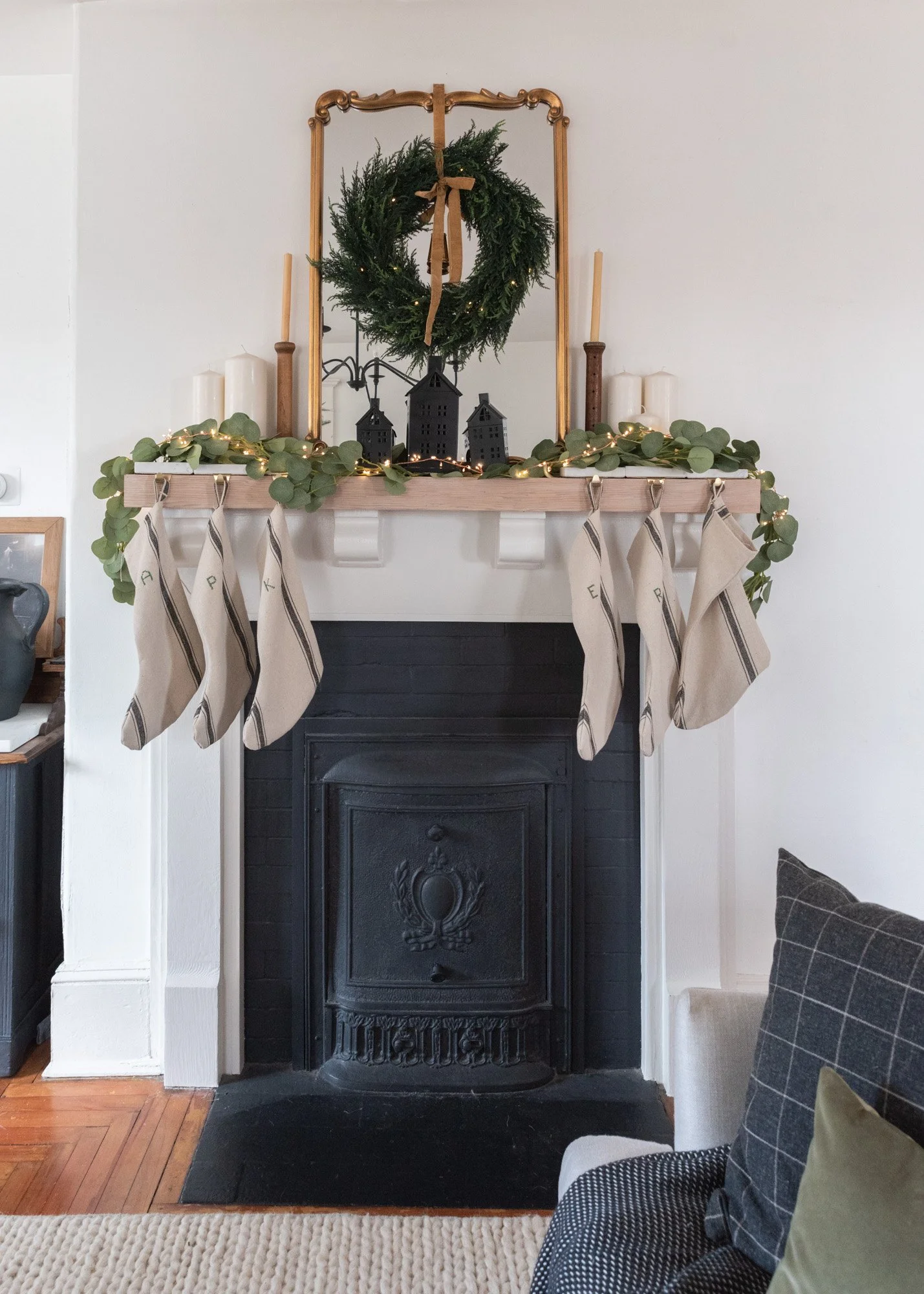 The Wild decoelis | 2020 Holiday Home Tour | Century home fireplace with Summer cover, black white and raw wood mantle, Flower sack handmade stockings with embroidered initials, twinkle lights, black houses, eucalyptus garland