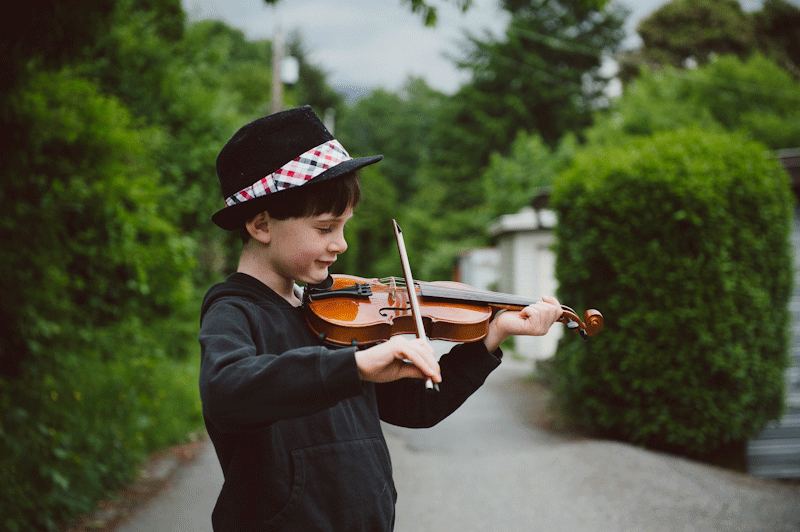 Уличный скрипач. Маленький скрипач. Играет на скрипке. Уличный мальчик.