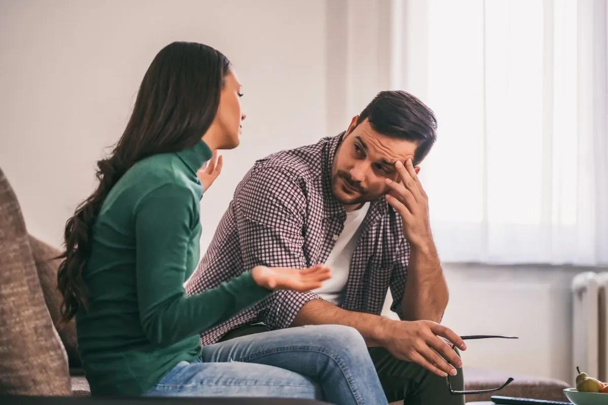 Couple sitting close on a sofa during a serious conversation about getting relationship support