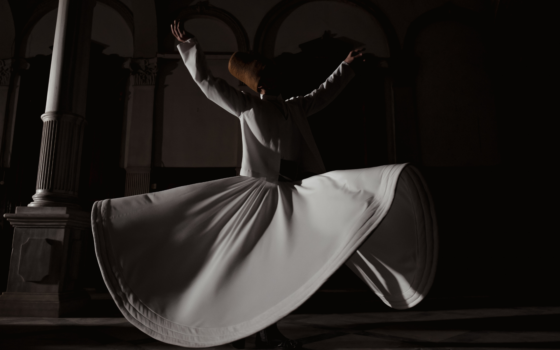 A whirling dervish in motion, robe arched outward