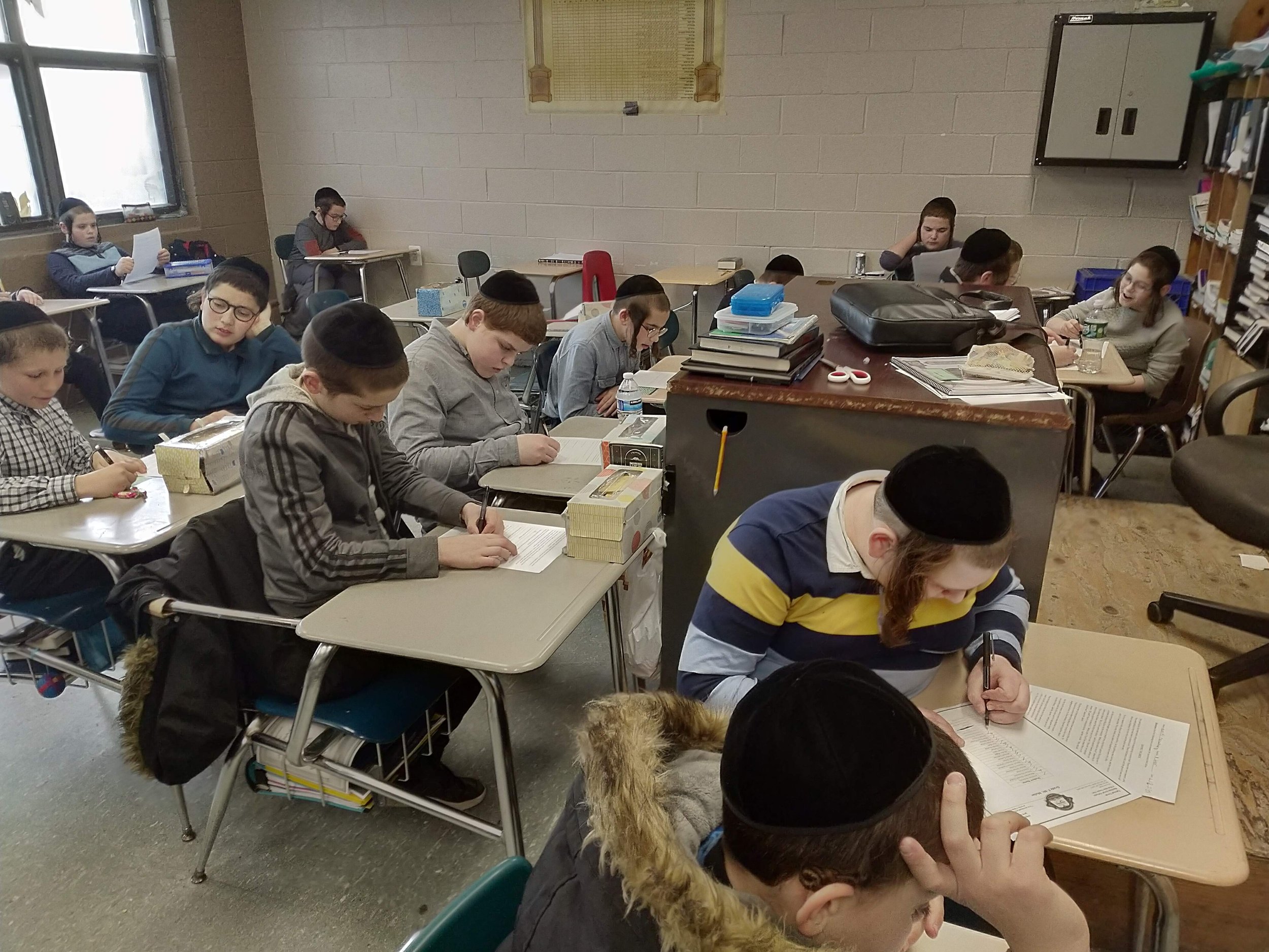A full class of students writing independently