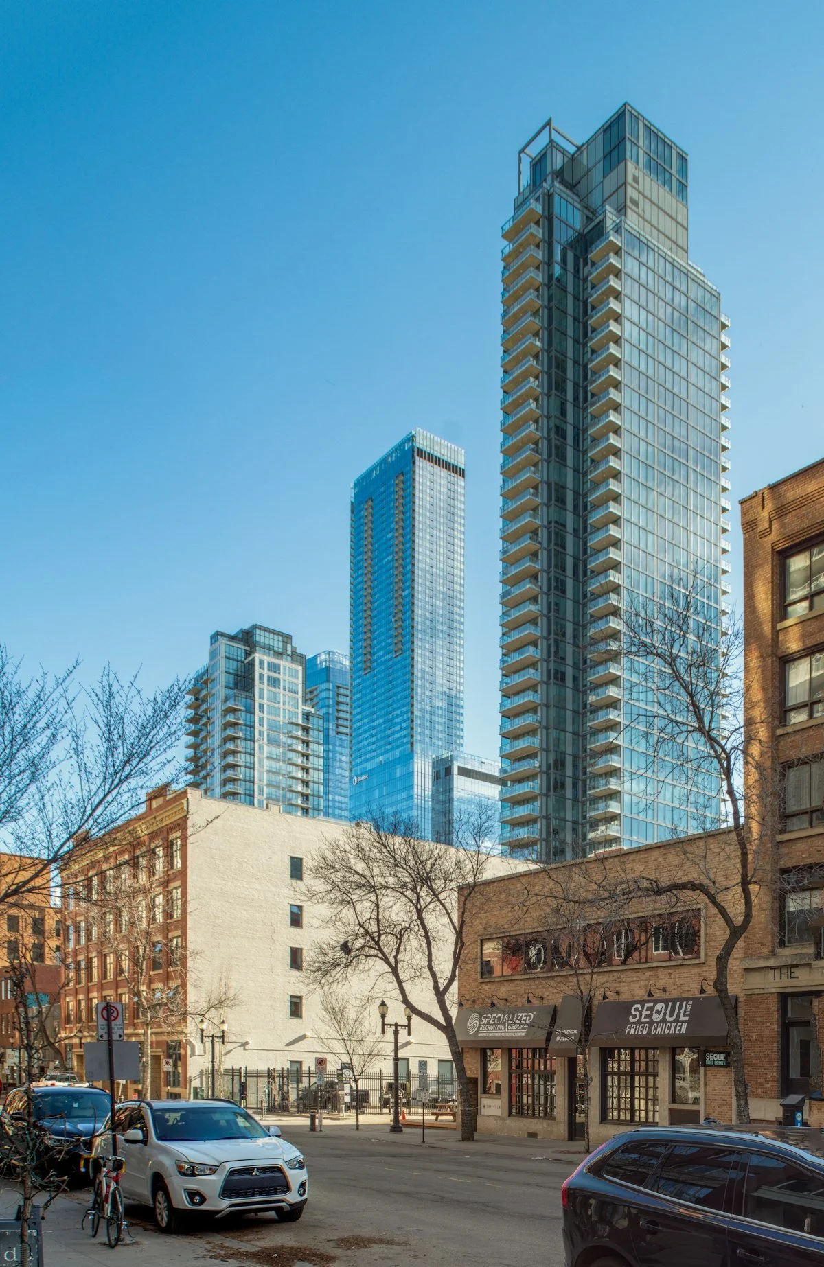 Sunlit glass residential towers above a city street