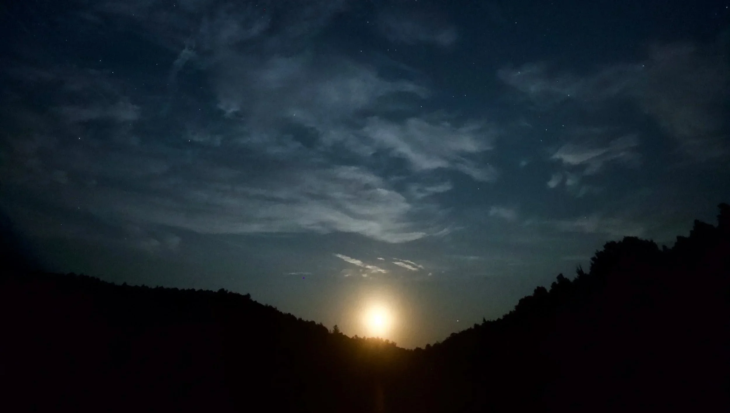 The moon rising over the silhouetted ridge at LeTerrain