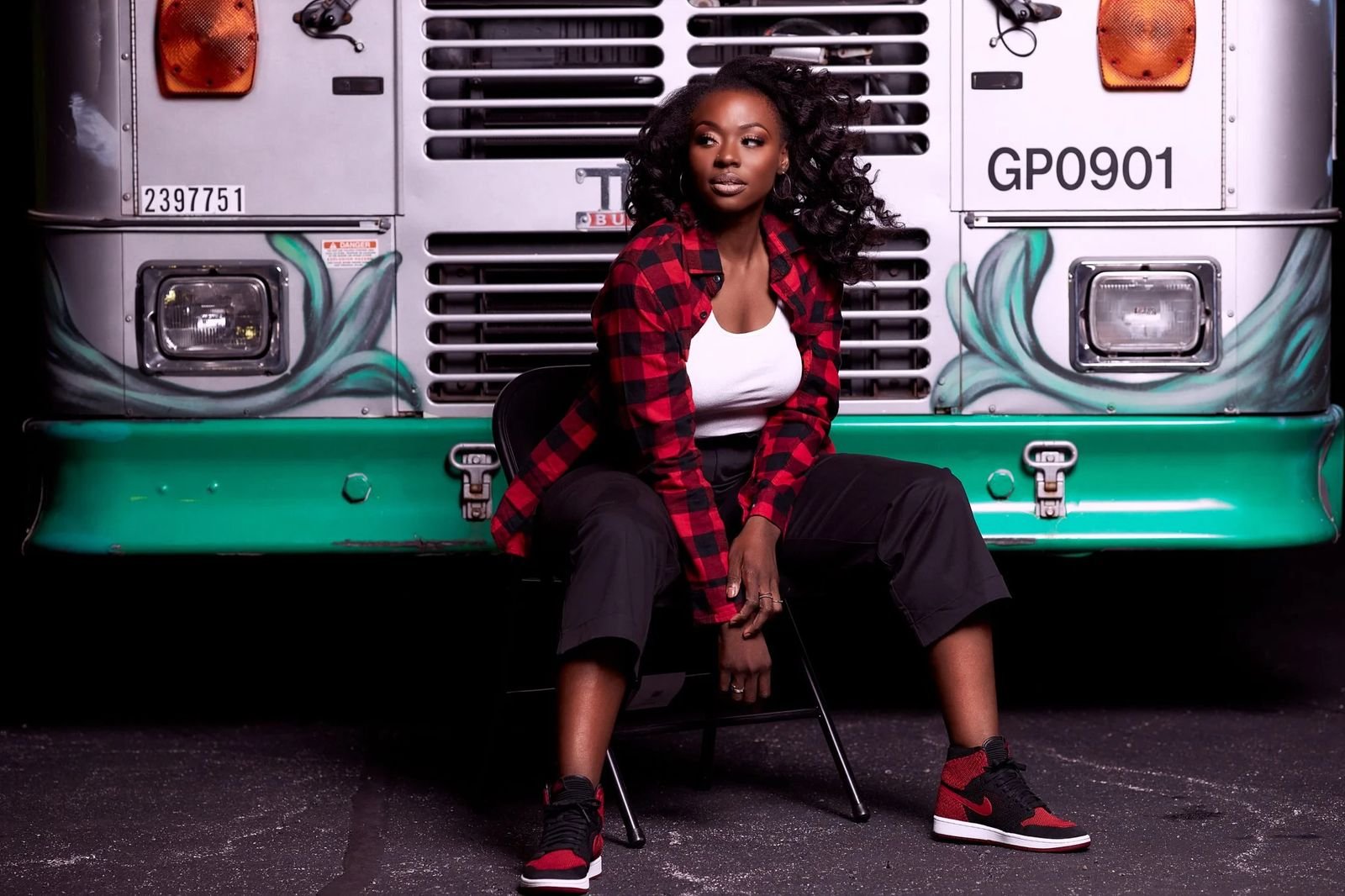 Portrait of a woman seated in front of a vintage bus