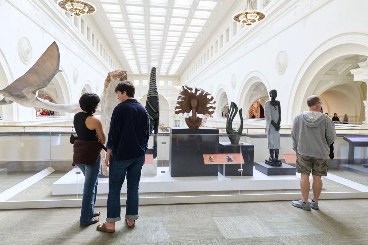 Visitors viewing sculptures in a large hall