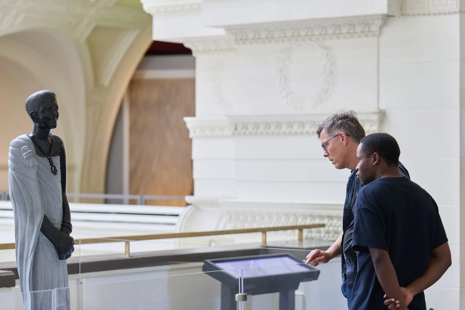 Two people looking at an exhibit in a large hall