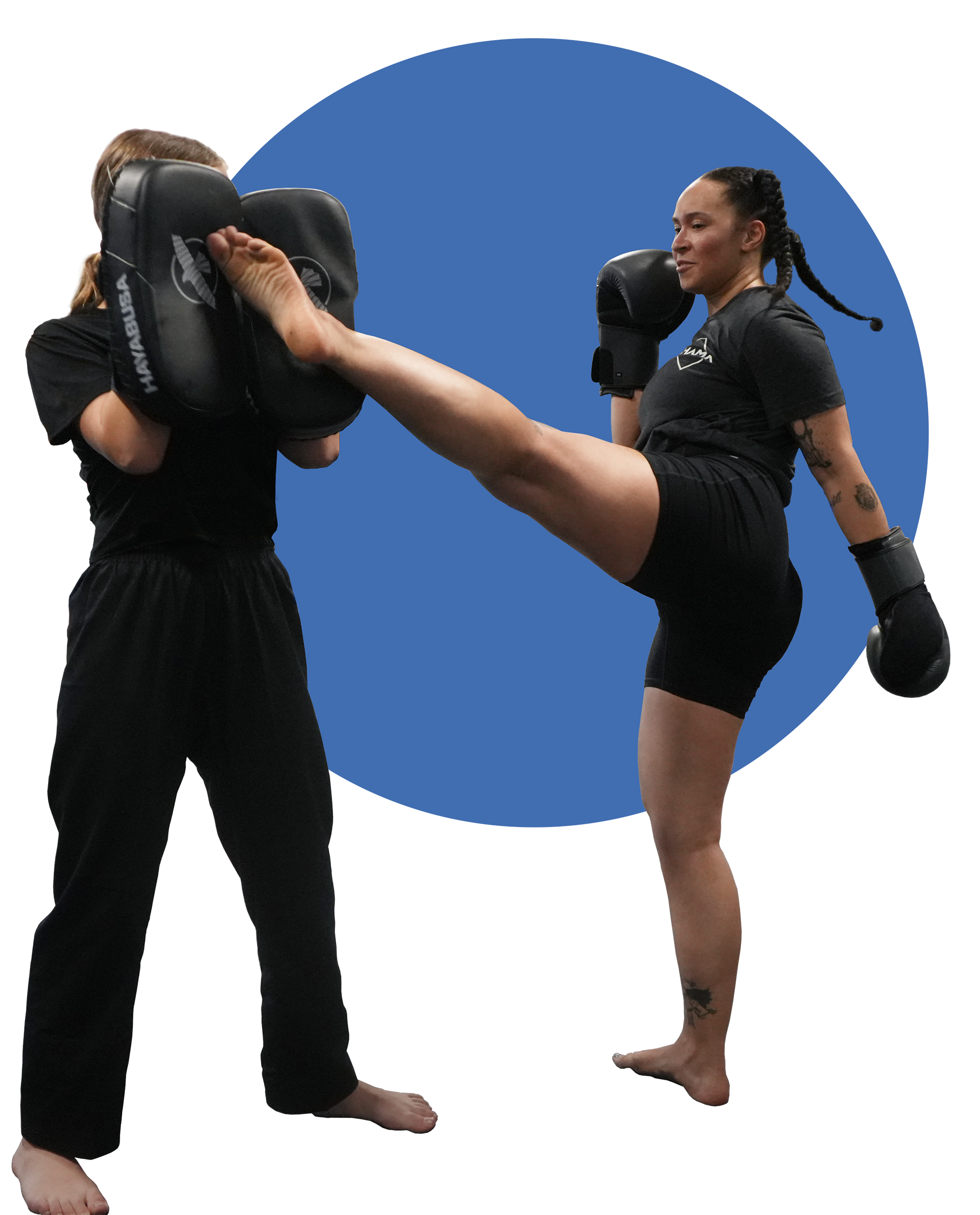 A student kicks pads held by another student.