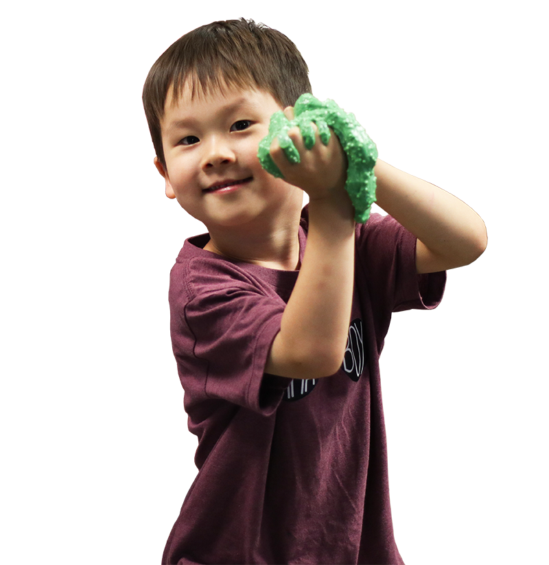 A young boy showing off green slime at camp.