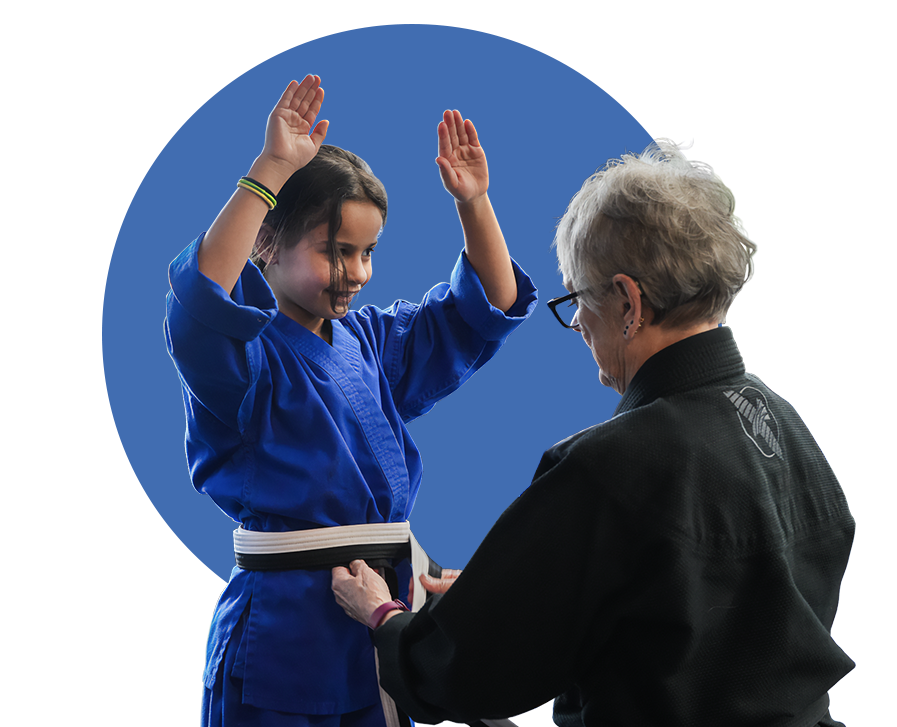 An instructor ties a belt on an excited student.