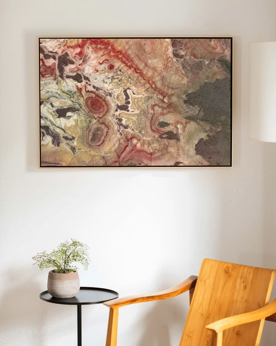 Natural wood float frame with abstract artwork above a wood chair and side table