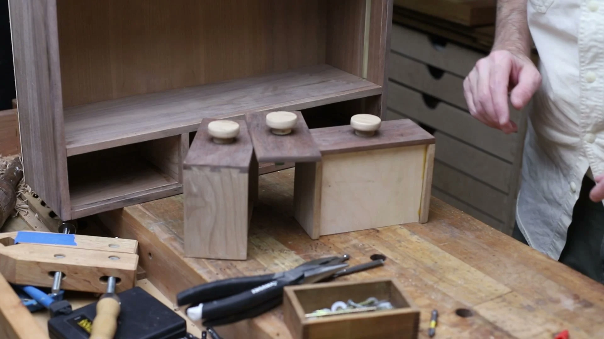 Three small drawers with contrasting round wooden knobs in front of the cabinet.
