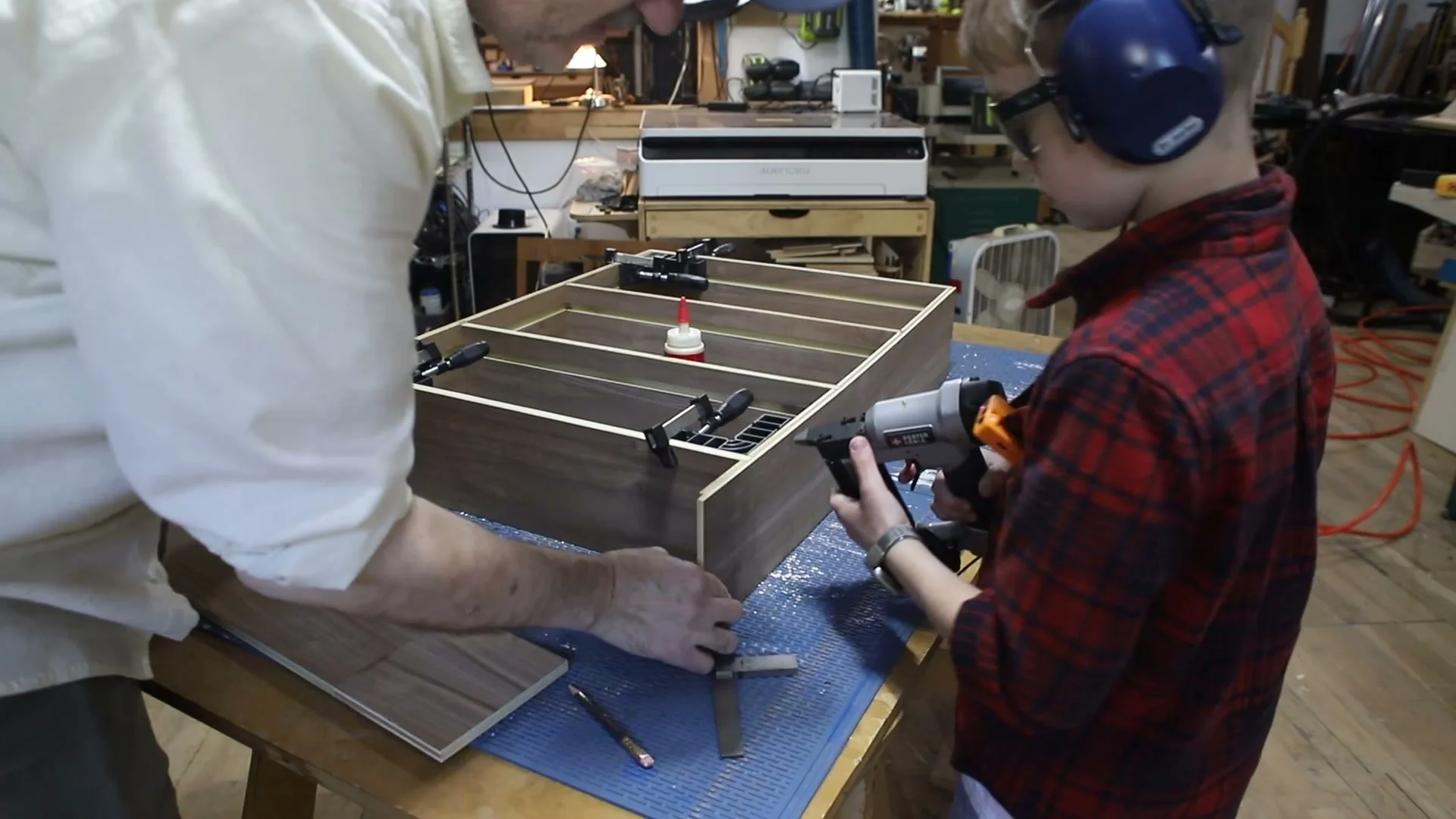 Walnut bookcase held in clamps during cabinet assembly.