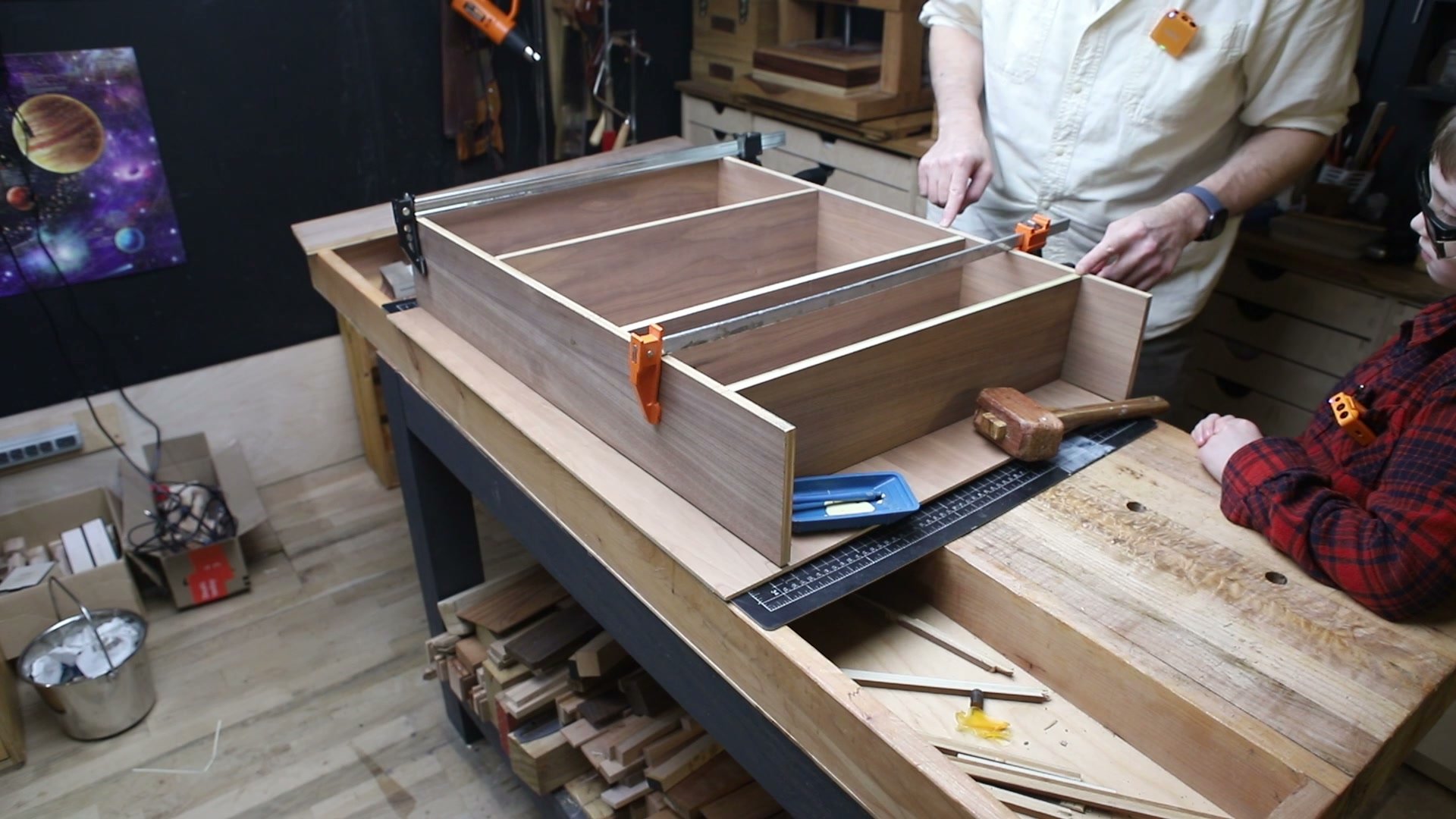 Walnut cabinet parts and shelf dividers being fitted on the workbench.
