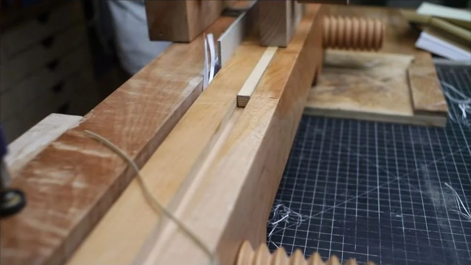 The sewn text block held securely in the wooden book vise before trimming