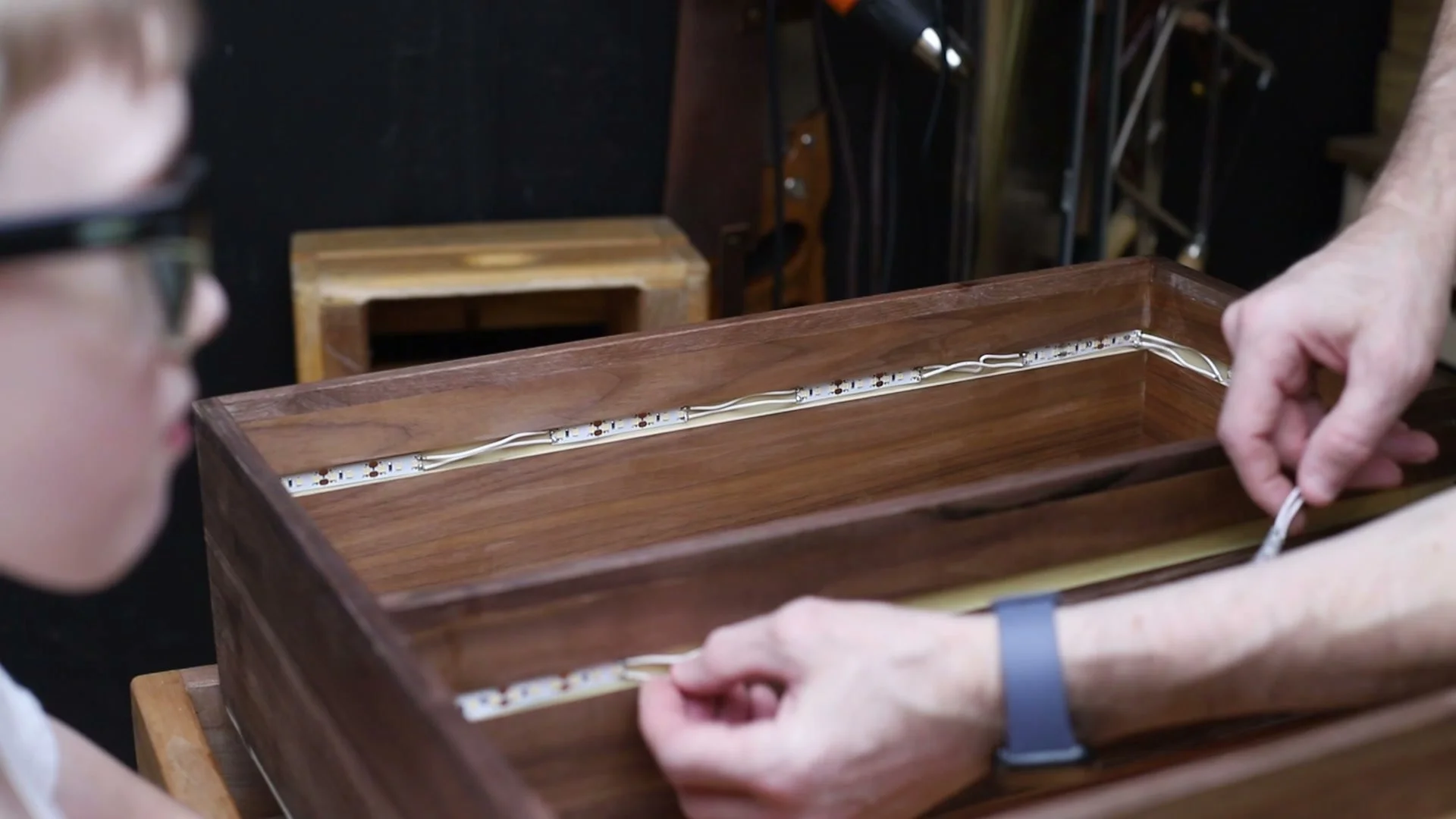 Installing LED strip lighting inside the walnut bookcase.
