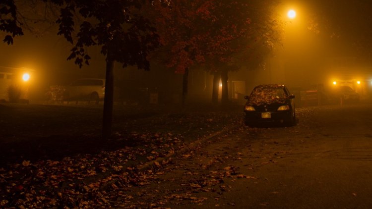 image of a car under a foggy street lamp.