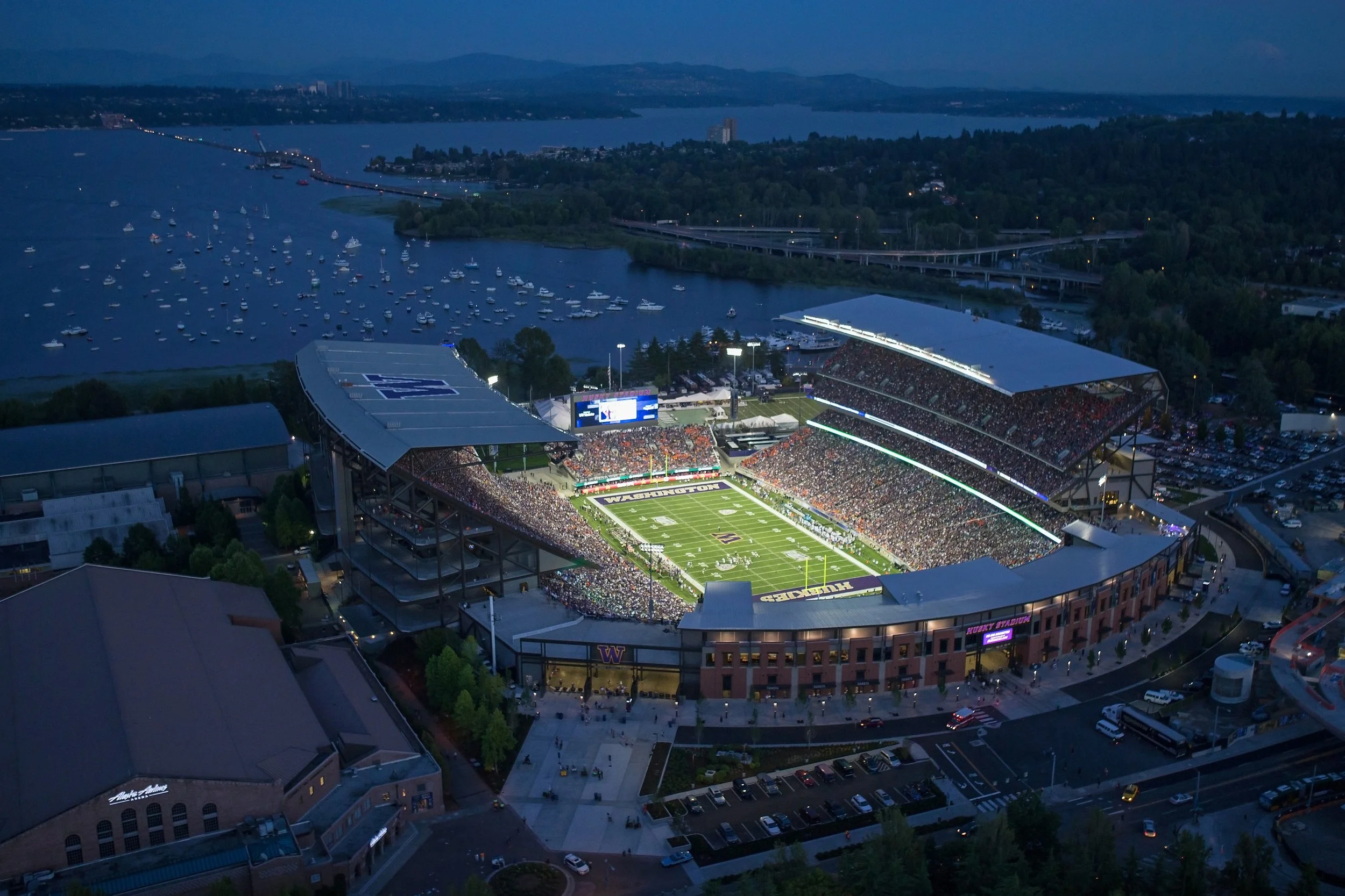 Aerial view of the University of Washington Husky Stadium beside Lake Washington at dusk