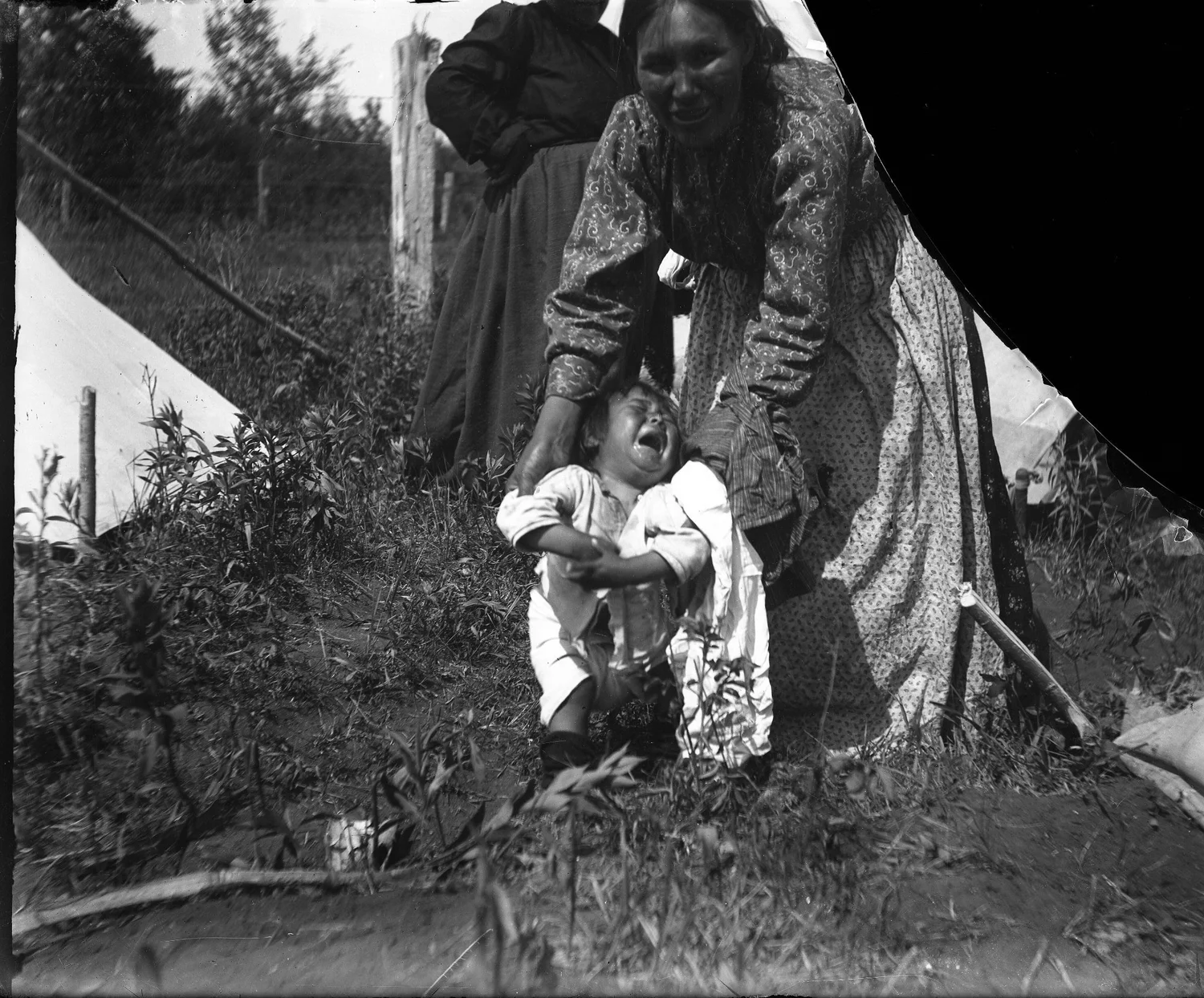 A woman holds up her crying infant