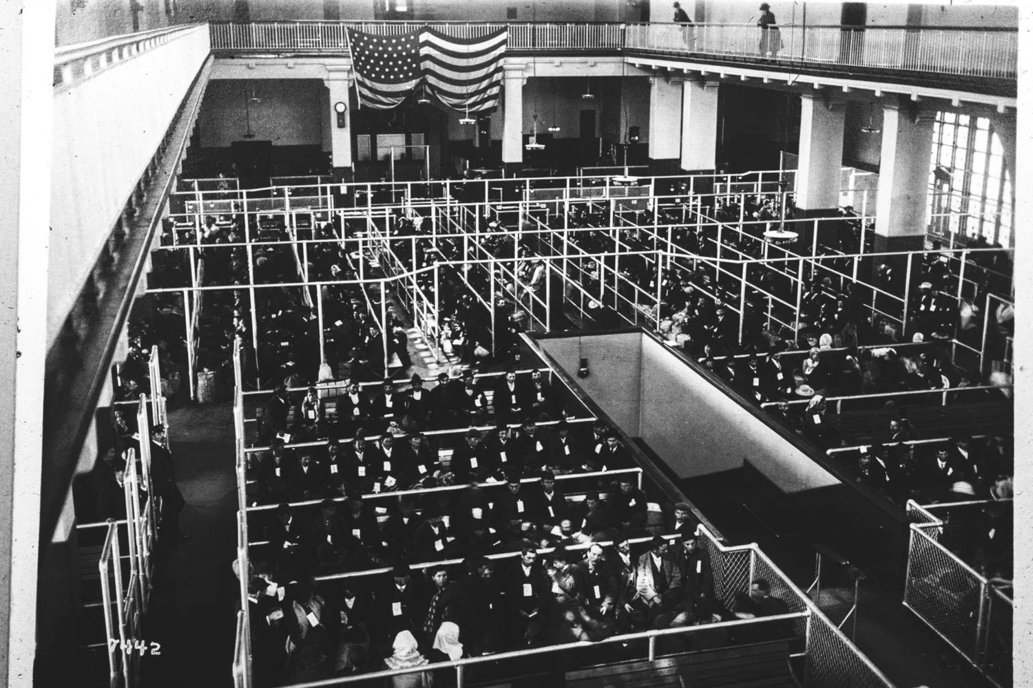 Rows of waiting immigrants fill the pens of the Ellis Island Registry Room