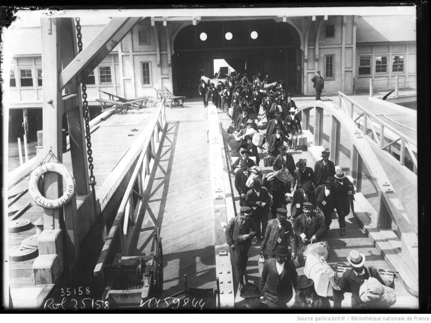 Immigrants crowd a gangway at Ellis Island