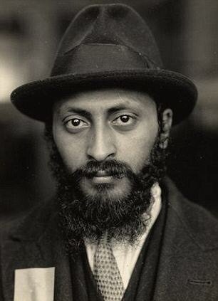 Portrait of a bearded man in a hat with an inspection tag on his coat