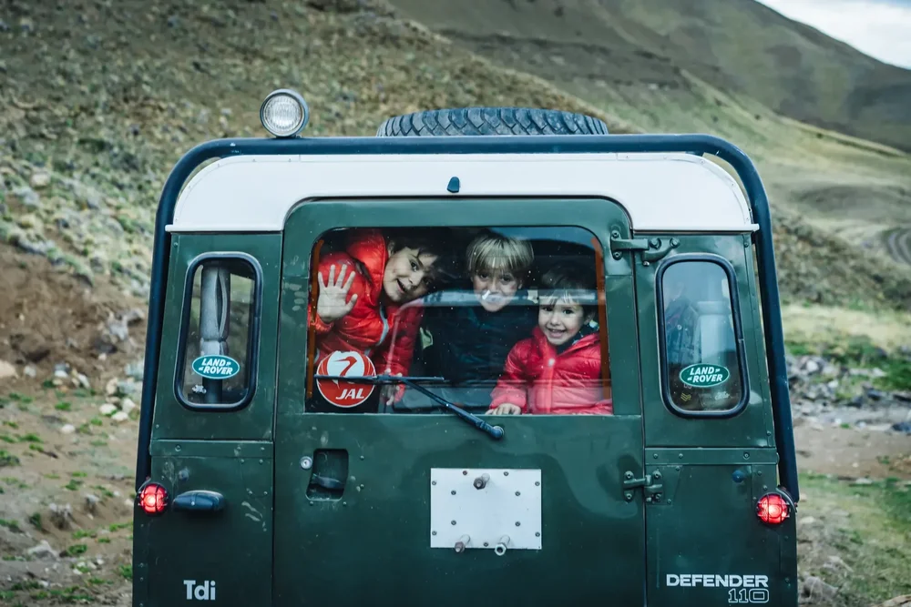Children in the back of a Land Rover Defender, Patagonia