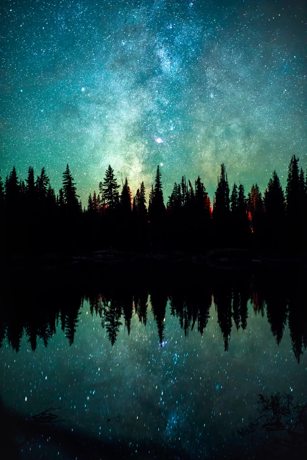 The Milky Way over Devils Lake, campfires burning in the treeline