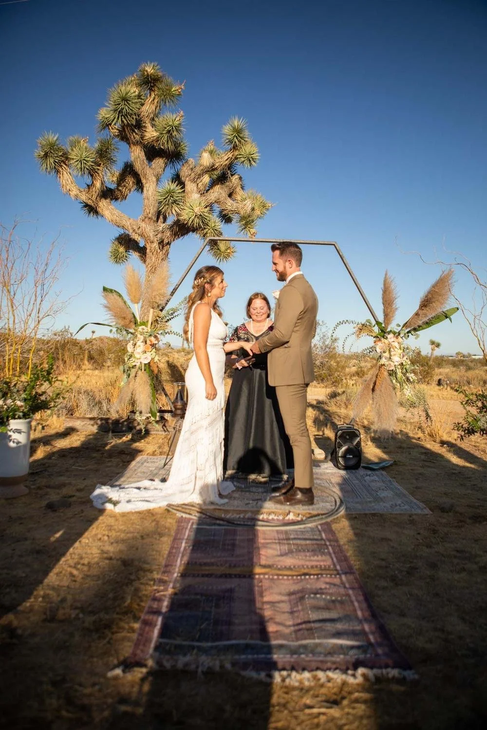 Bride and groom embracing during their wedding portraits in the desert at Serenity Escape, Yucca Valley, California