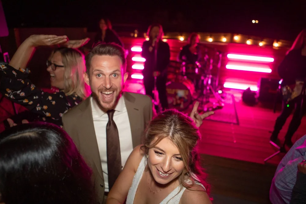 Guests dancing under pink and purple lights during the wedding reception at Serenity Escape in Yucca Valley, California