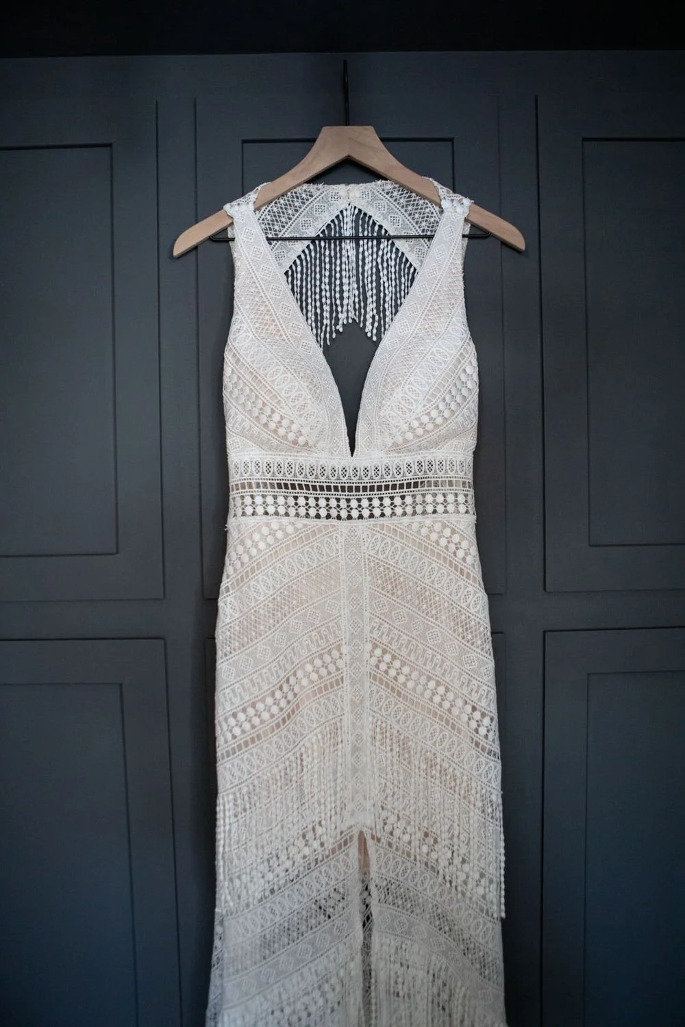Elegant wedding dress hanging on a dark wooden door at Serenity Escape in Yucca Valley, California
