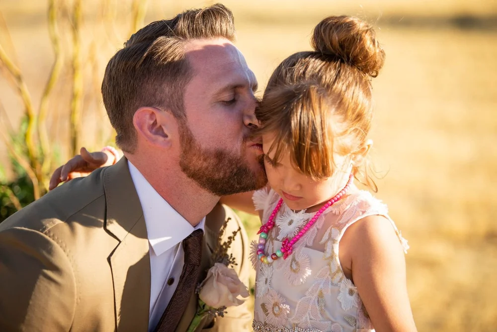 Bride and groom sharing their first kiss during their outdoor desert wedding ceremony at Serenity Escape in Yucca Valley