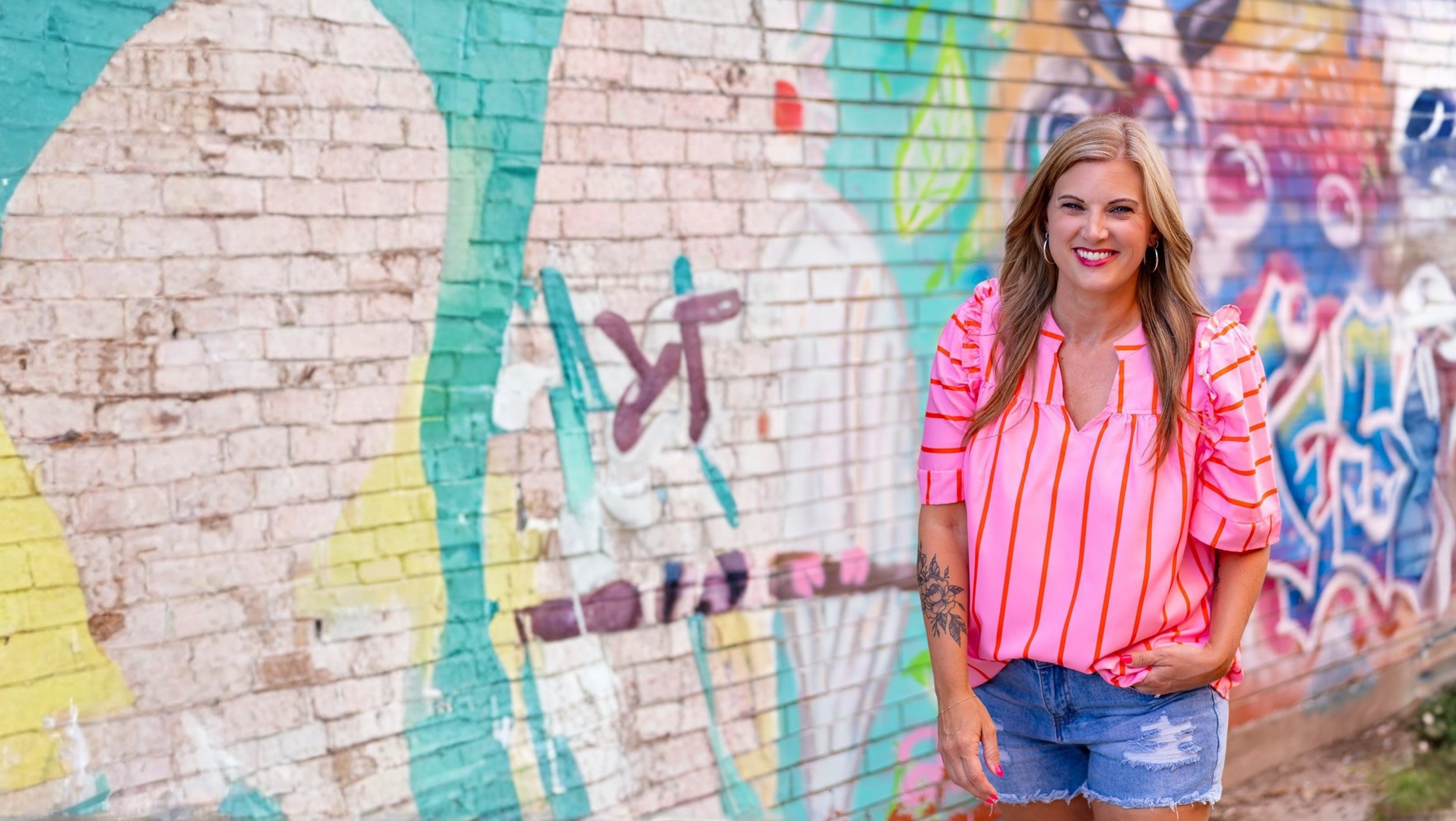 Kara-Kae James in front of a mural
