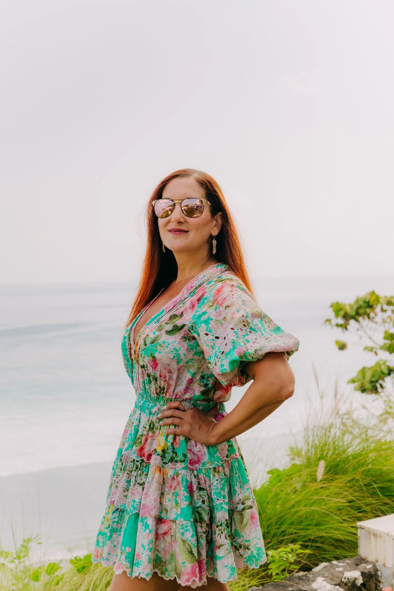 Laura in sunglasses standing before a wide ocean view in Bali