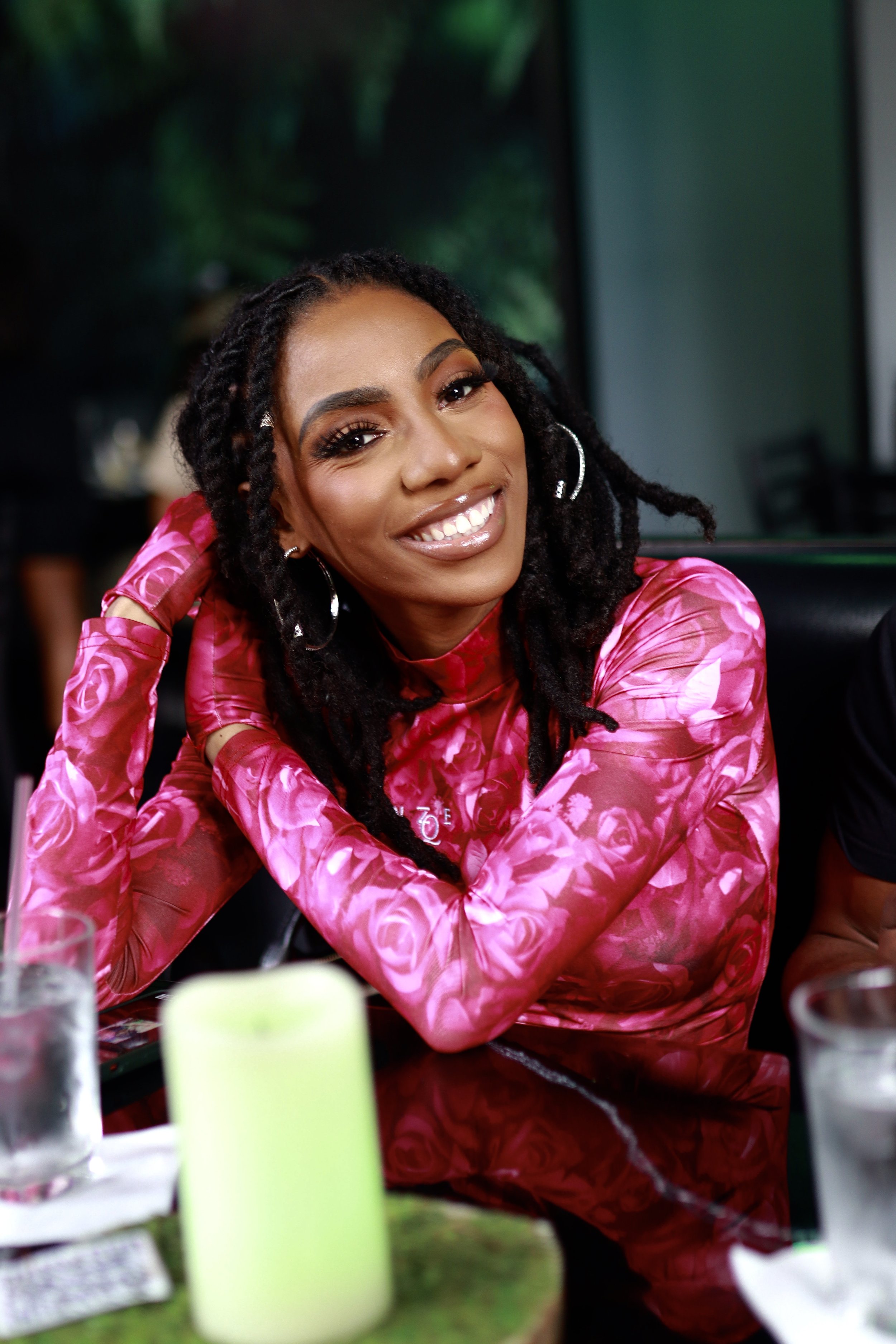 Smiling customer in a pink floral dress, photographed by Kronos Pictures after glam by Dej