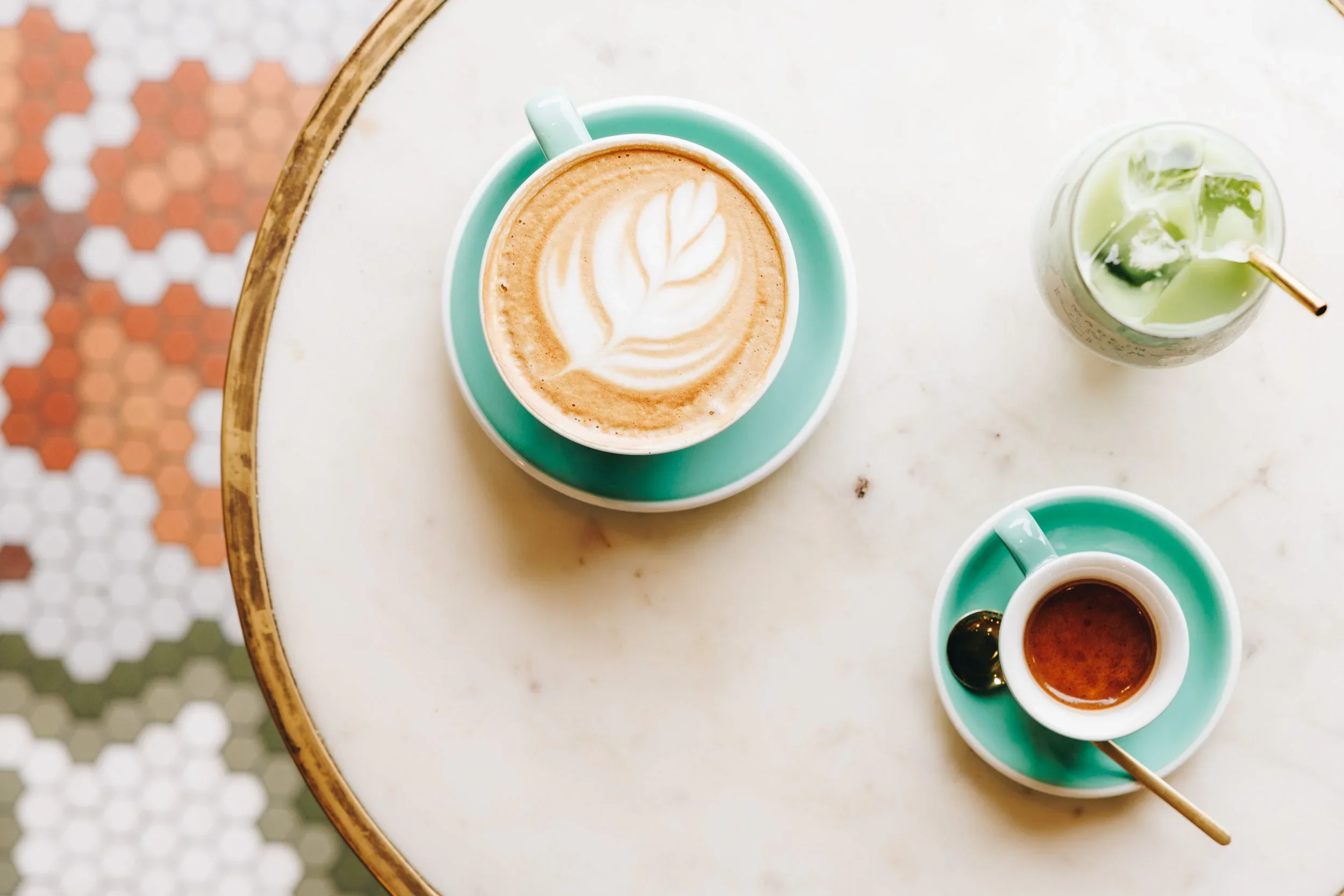Blake Hamilton’s photograph of coffee and a green iced drink on a café table at Made in KC Café.