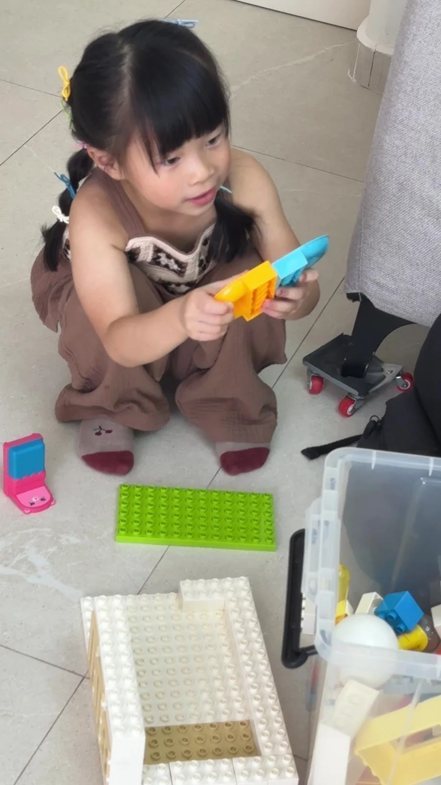 Older sister playing with toys during a break in a Mamamiyo newborn home photoshoot in Singapore.