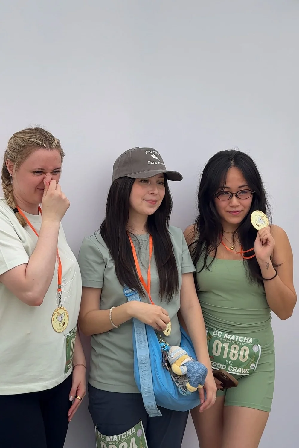 Three crawlers holding up their medals beside the open-air photo booth
