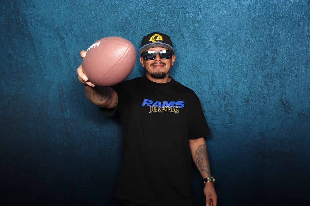 A member holding out a football at the LA Rams member night photo booth