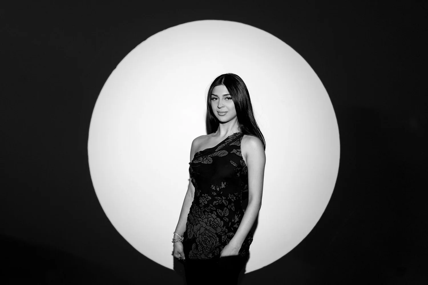 Black-and-white Kardashian-style glam photo booth portrait of a guest framed by a circle of light