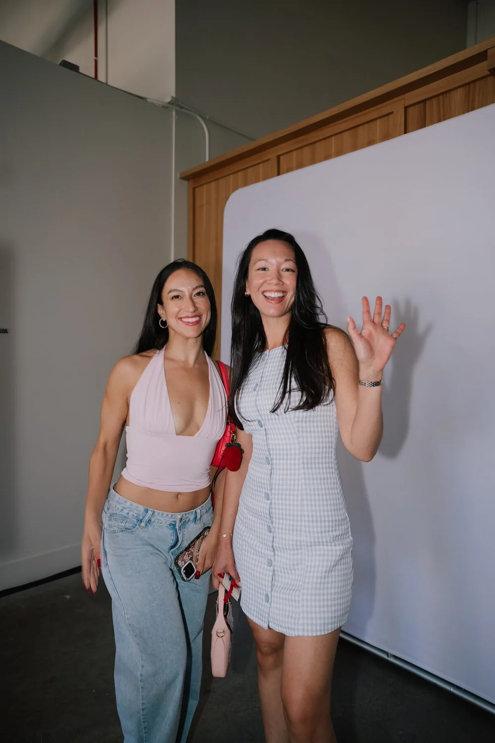 Two guests waving beside the photo booth at the Cherry Golf Club collaboration