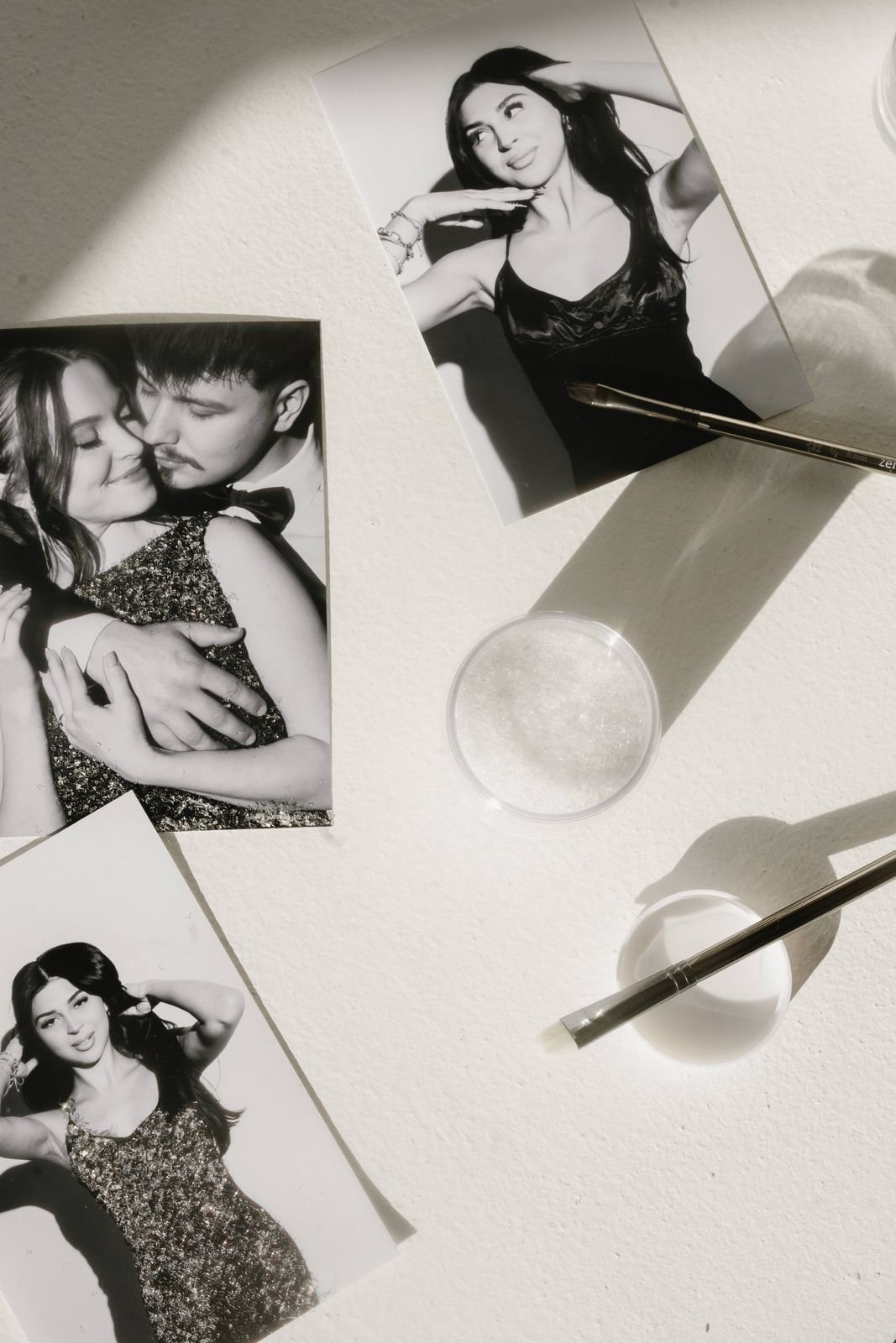 Classic black-and-white vintage photo booth strips scattered on a white table