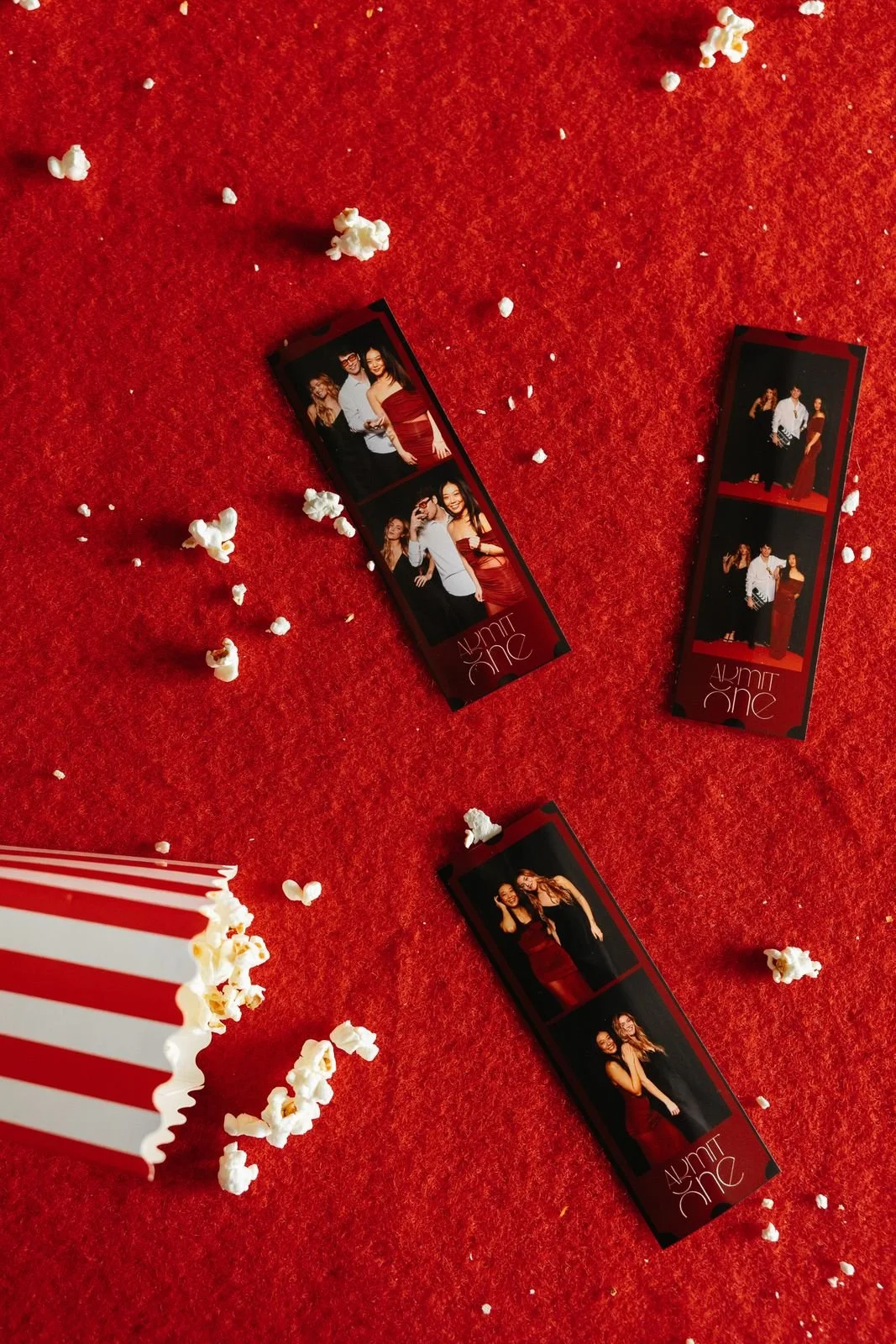 Two classic photo booth strips on a red carpet, the signature keepsake of an enclosed booth