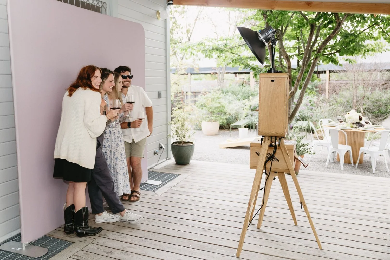 Wooden photo booth set up on a backyard deck for a private party