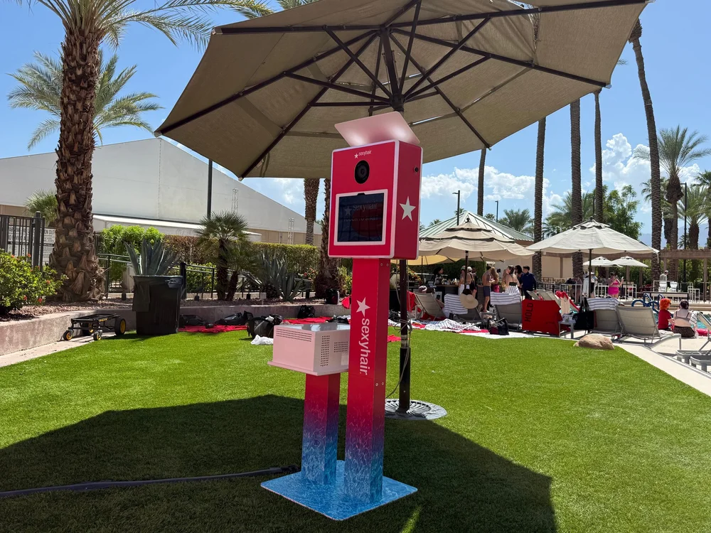 Fully wrapped Sexy Hair open-air photo booth poolside under an umbrella at Hairbrained Fest