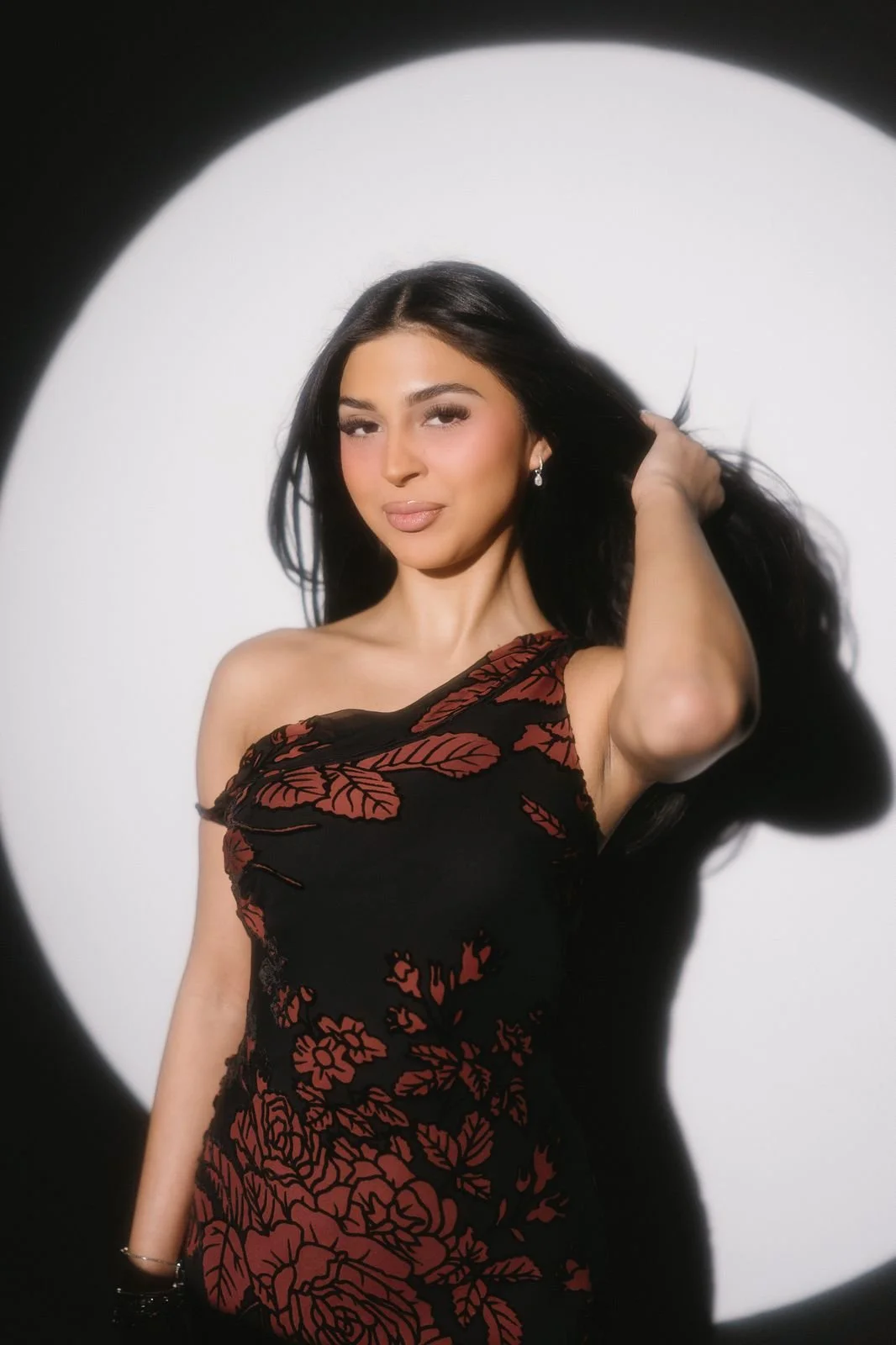 Full-color glam booth portrait with soft beauty lighting and a deep shadow behind the guest