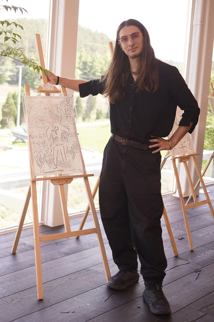 Matthew C. Kramer standing next to one of his drawings on an easel
