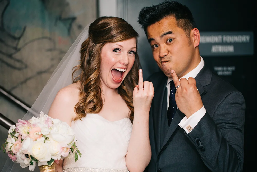 newlywed couple holding up ring fingers