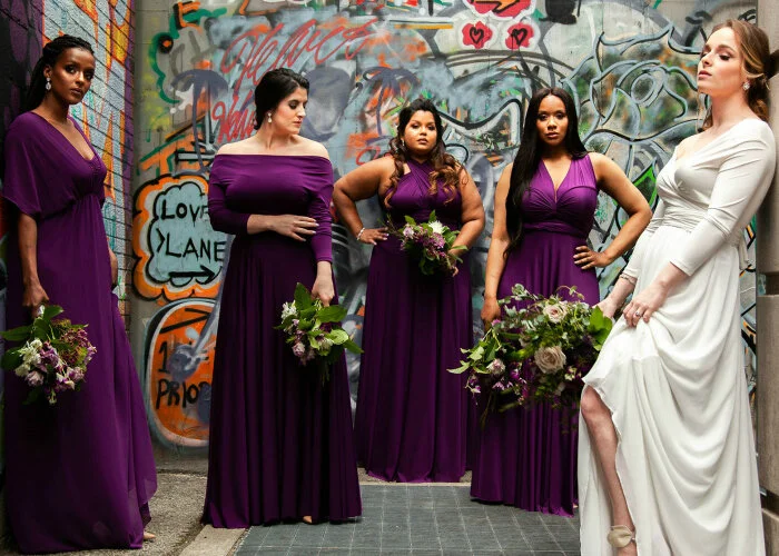 bride and bridesmaids wear Henkaa wedding dresses in alley surrounded by graffiti Toronto
