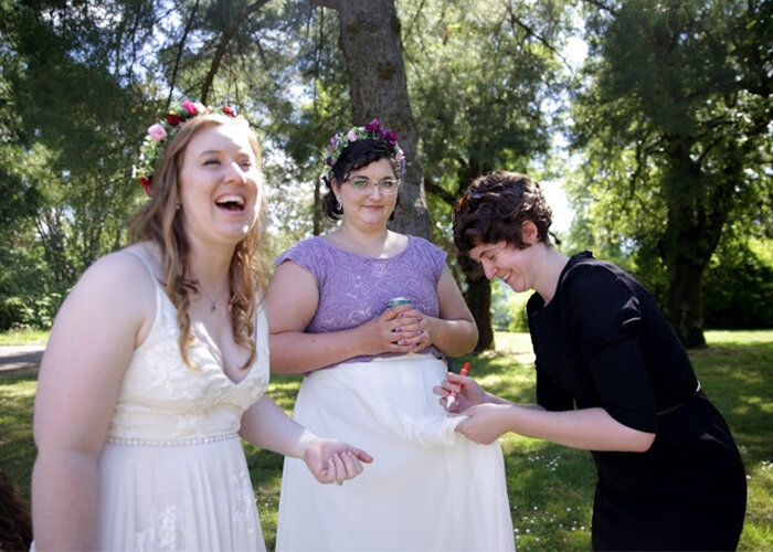 Wedding coordinator Elisabeth Kramer uses tide ben on wedding dress skirt as marrier laughs